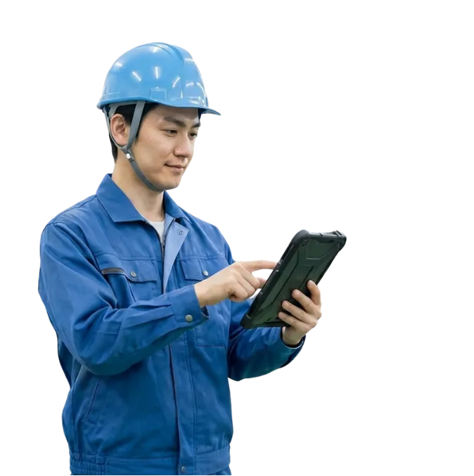 青いヘルメットと作業着を着用した製造業の男性がタブレットを操作している様子